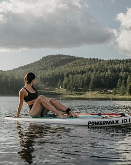 pexels-photo-7537869-7537869 A woman in swimwear enjoys the tranquility of a serene lake surrounded by lush forest and mountains.